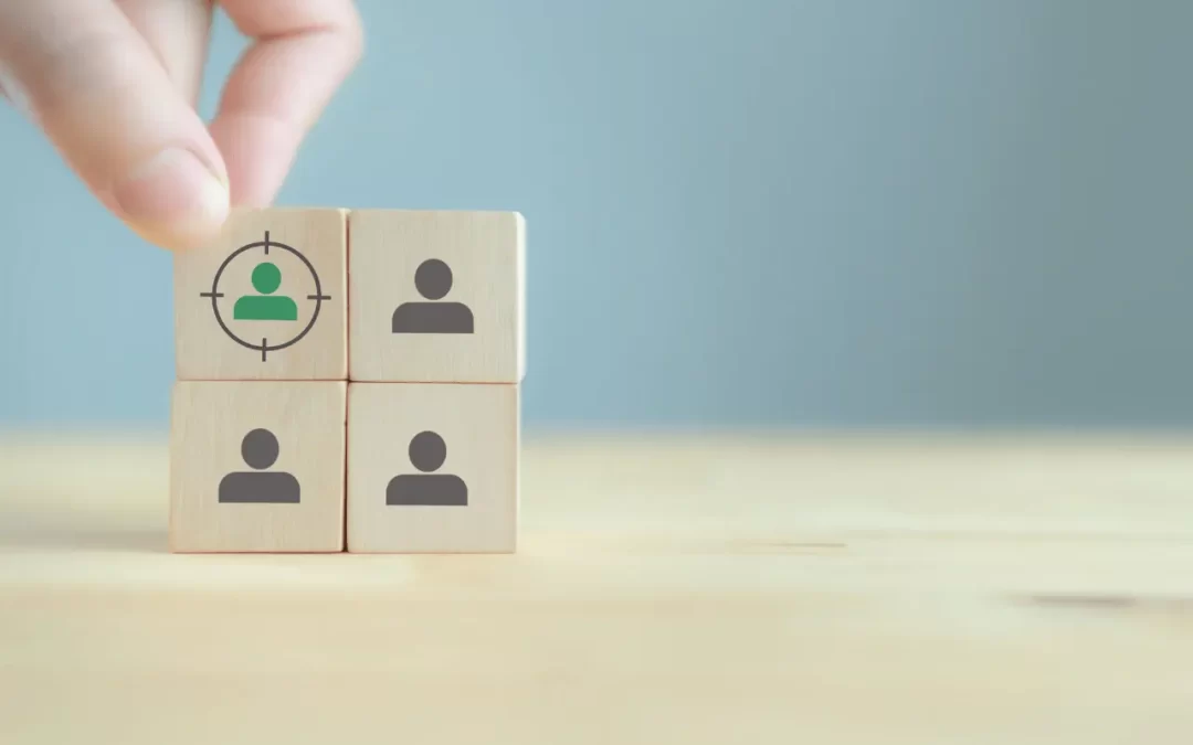 Image of four wooden blocks with people on them, one with a target to depict a 'target audience'.