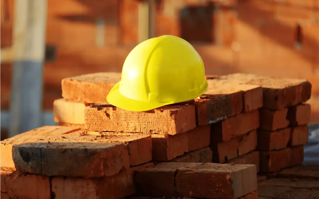 Construction PR and Marketing - Image of a yellow hard hat sitting on a stack of bricks.