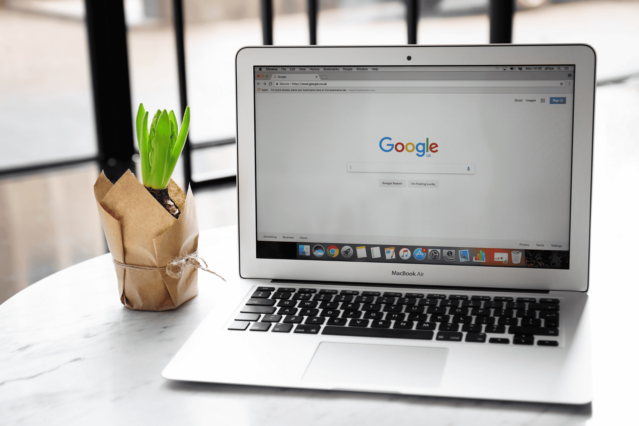 Paid Advertising Agency - Image of a laptop on a marble desk with a Google page open.