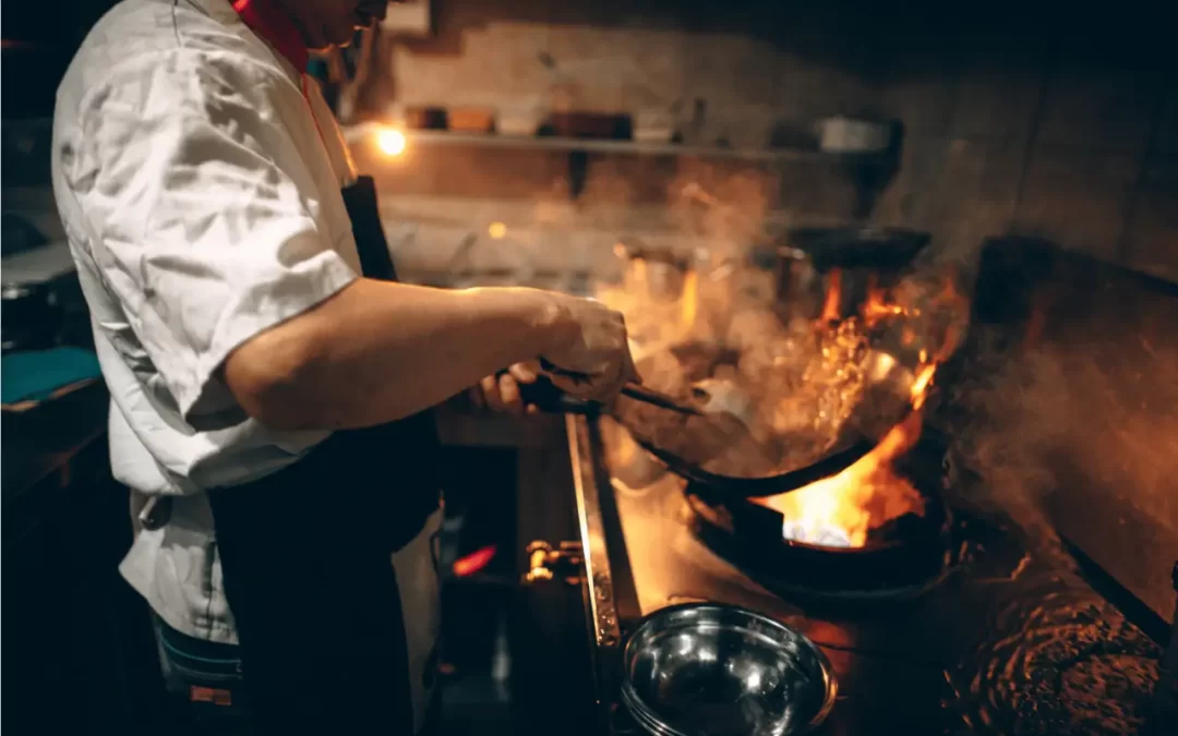 Restaurant Social Media Marketing - Image of a chef in a restaurant kitchen cooking a meal.